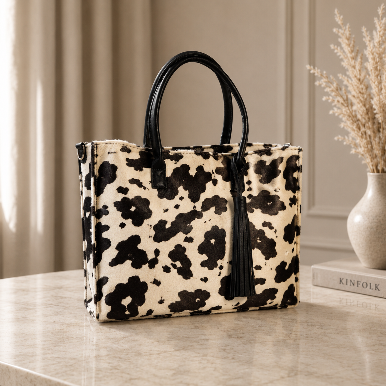 Cartera Tote Milagros negro y blanco confeccionada en cuero y pelo natural con asas de cuero negro.
